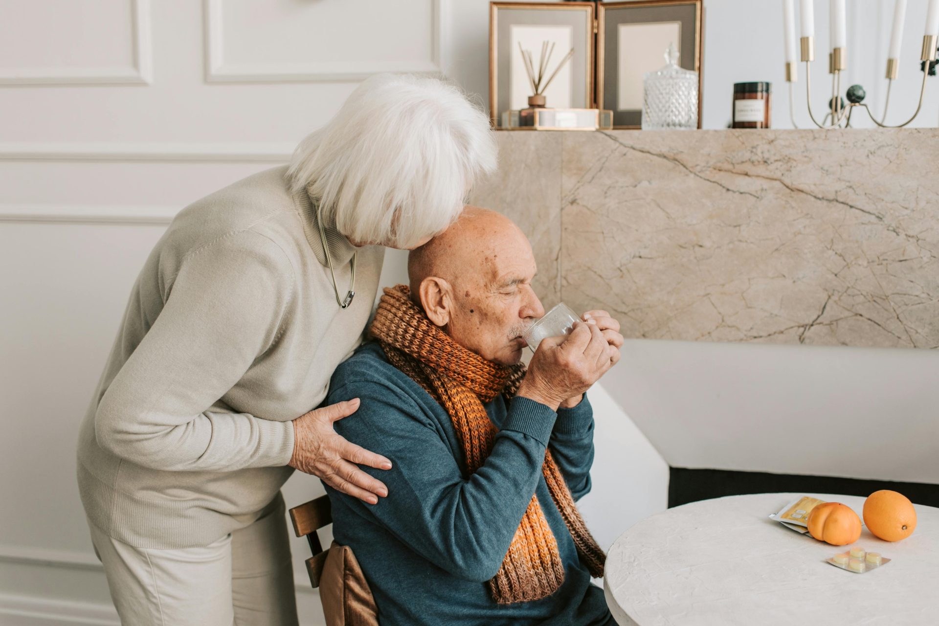 A loving elderly couple sharing a tender moment in their cozy home setting.